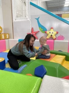 Emily Mai playing with her child at a soft play center. 